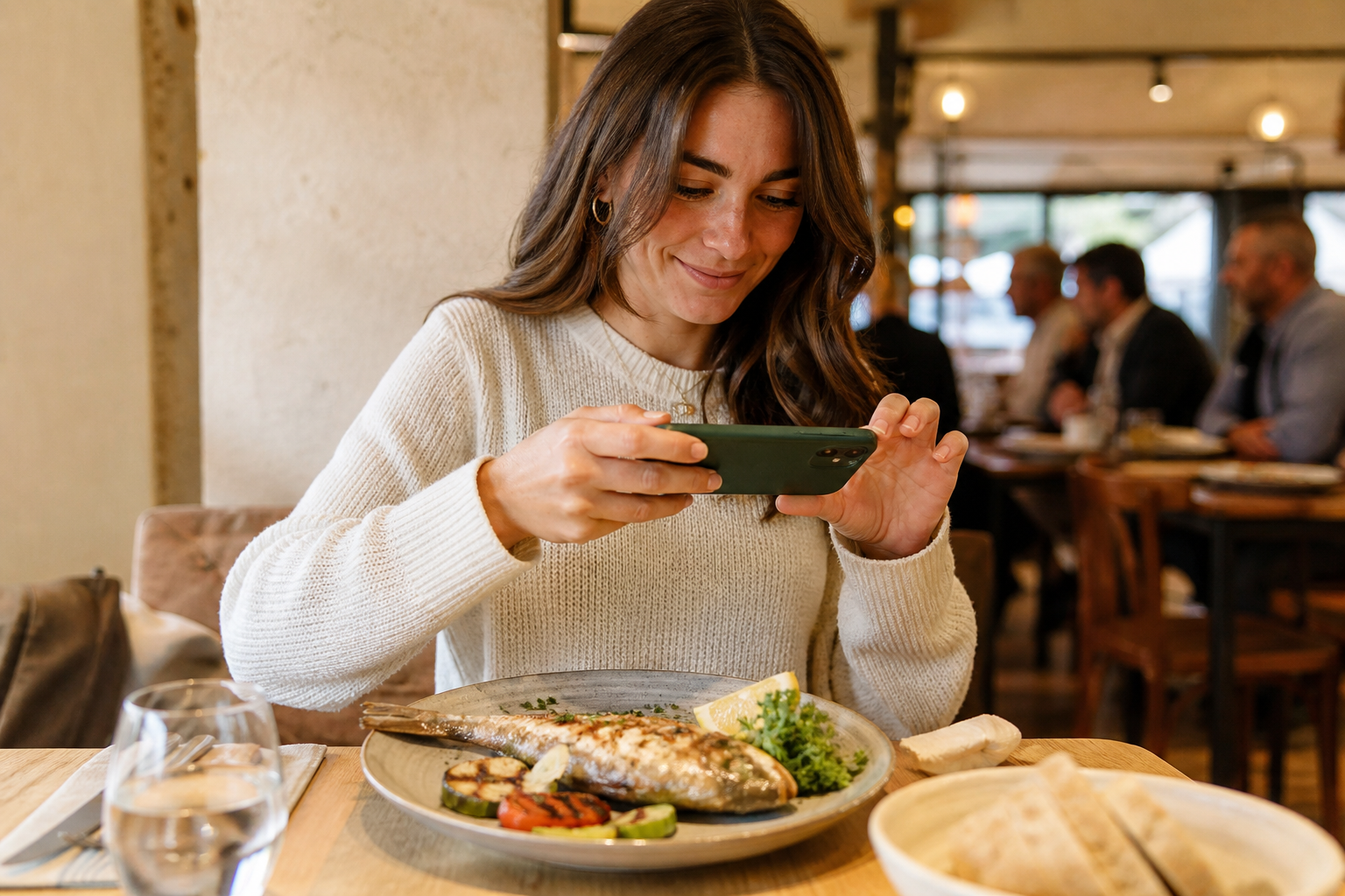 Person taking a quick photo of their dish in a restaurant naturally and relaxed
